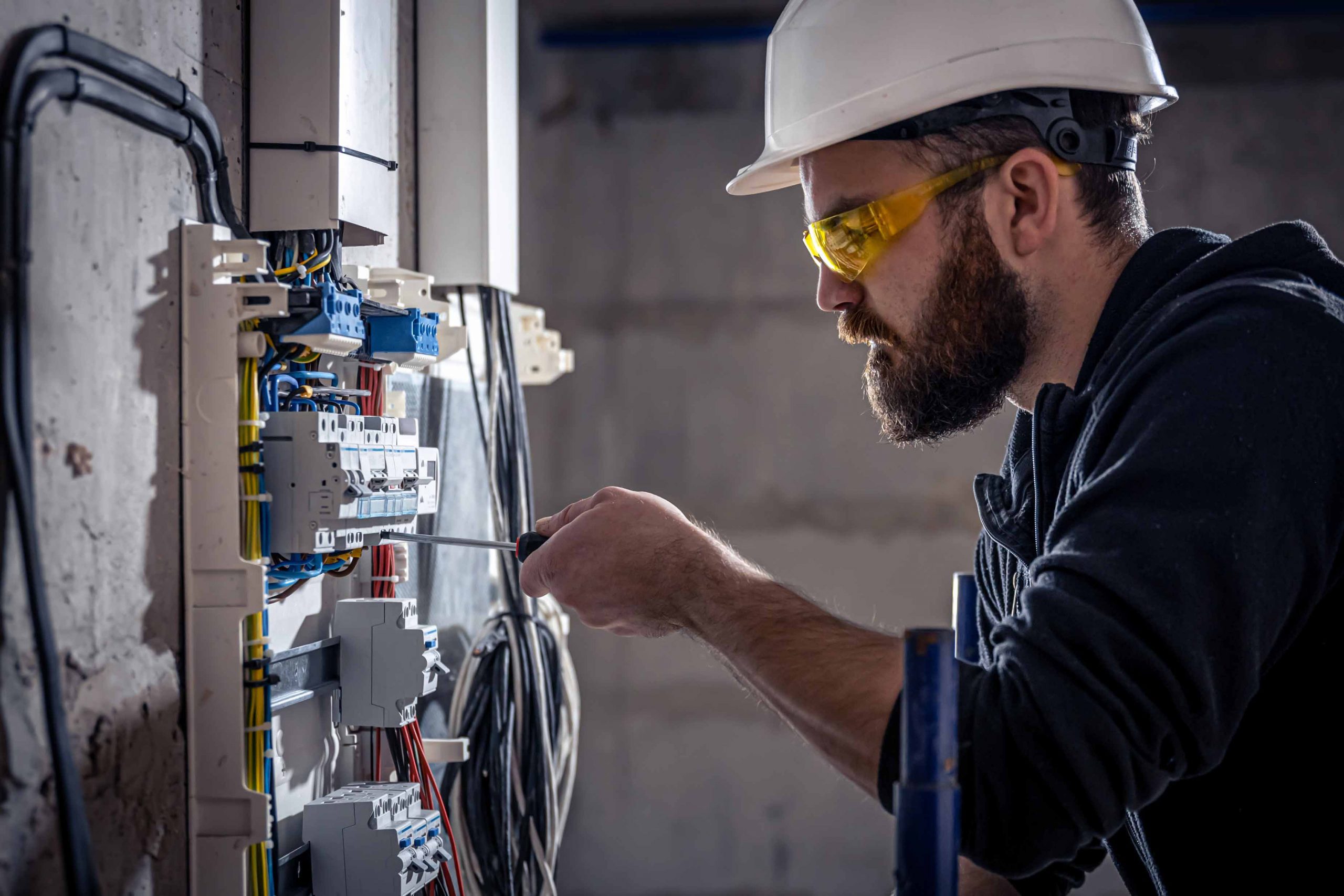 Homem fazendo manutenção em quadro elétrico